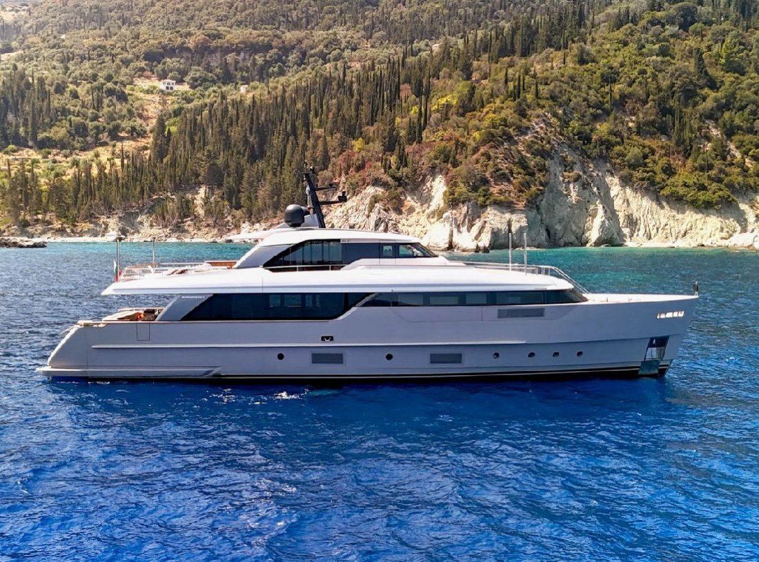 FLORI at anchor near a wooded coast